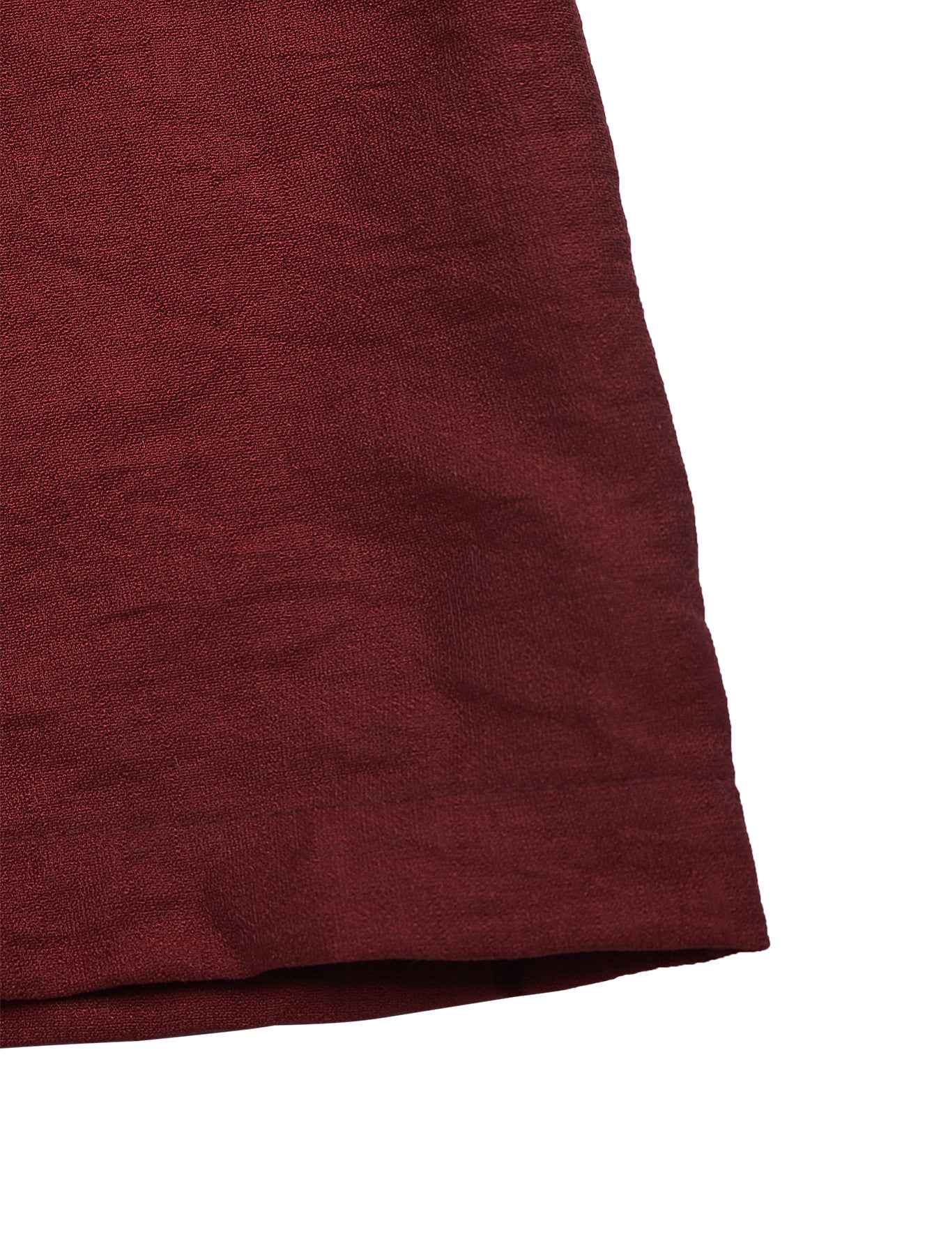Close-up of burgundy wide leg jumpsuit hem showing soft textured fabric quality and clean stitched finish